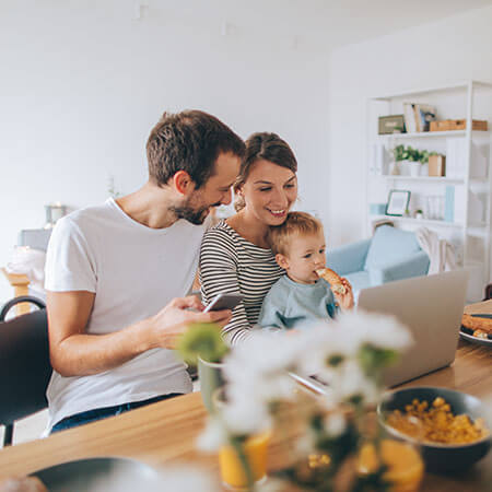 a young couple with a child looking at a laptop