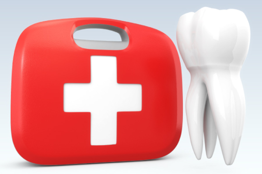 Red emergency kit with a white cross next to a model of a tooth.
