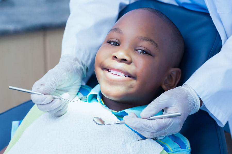 Smiling dimpled black boy in the dental chair 